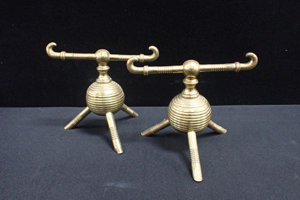 ATTRIBUTED TO DR CHRISTOPHER DRESSER: A PAIR OF BRASS FIRE DOGS