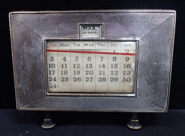 A SILVER FRONTED DESK CALENDAR