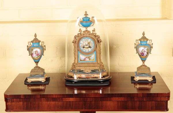 A GILT METAL AND PORCELAIN MOUNTED MANTEL CLOCK WITH GARNITURE BY BRUNFAUT