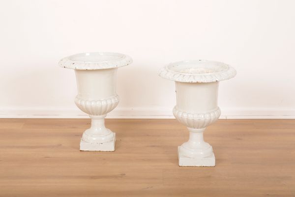 A PAIR OF VICTORIAN WHITE PAINTED CAST IRON GARDEN URNS