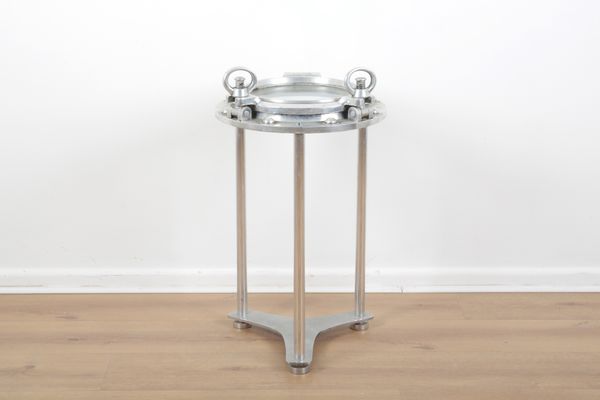 A POLISHED ALUMINIUM PORTHOLE OCCASIONAL TABLE