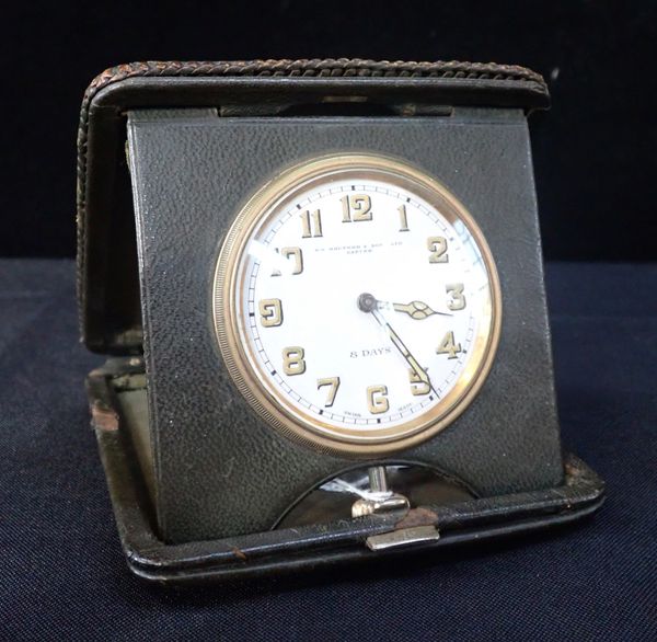 AN EDWARDIAN GREEN LEATHER CASED TRAVEL CLOCK