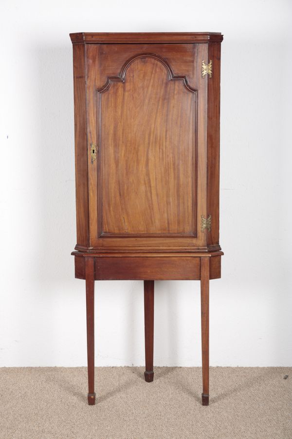 A GEORGE III MAHOGANY CORNER CUPBOARD ON STAND