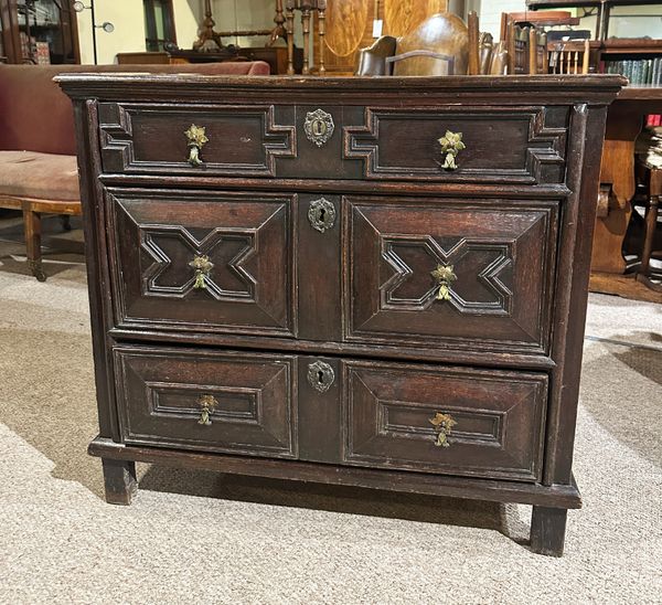 AN OAK CHEST OF DRAWERS