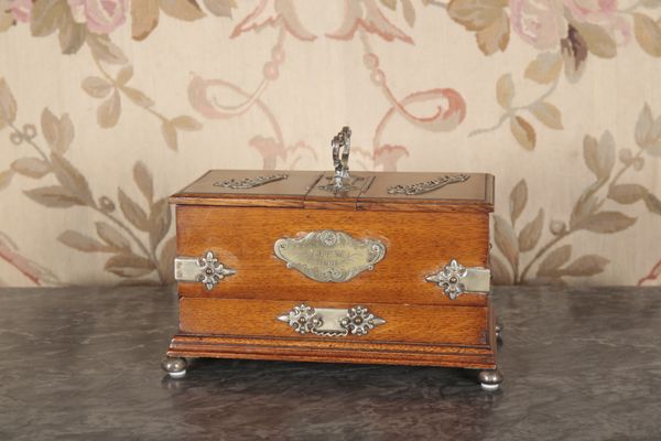 AN EDWARDIAN OAK AND METAL MOUNTED SMOKER'S COMPANION