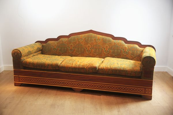 A HARDWOOD THREE-SEATER SOFA WITH ARCHED MORESQUE BACK RAILS