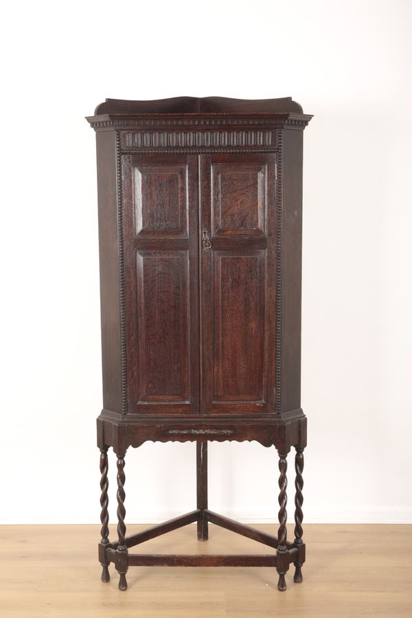 A 1920S OAK CORNER CUPBOARD ON STAND