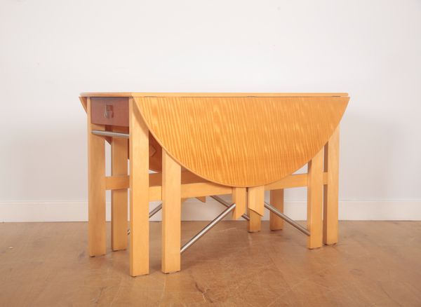 ANDREW VARAH (20TH CENTURY): A DROP LEAF CIRCULAR DINING TABLE IN EXOTIC WOODS