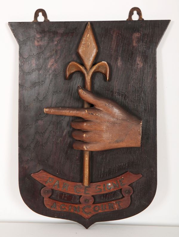 A CARVED WOODEN SHIELD-SHAPED PANEL BEARING THE CREST AND MOTTO FOR SIR BERTINE ENTWISLE FROM THE 15TH CENTURY