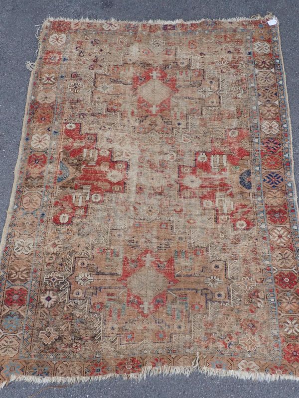 AN ANTIQUE TRIBAL RUG, IN MUTED COLOURS