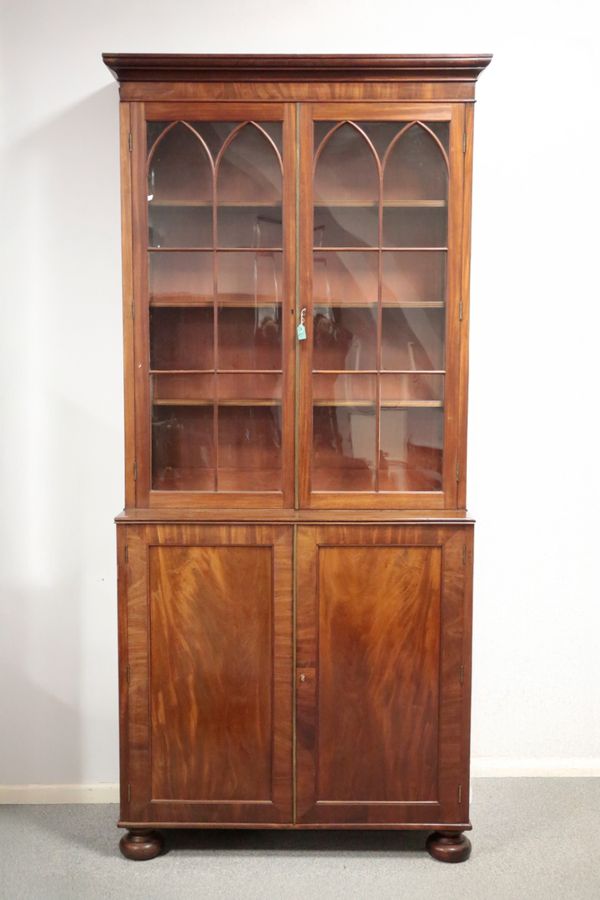 A FLAME MAHOGANY AND GLAZED BREAKFRONT BOOKCASE CABINET