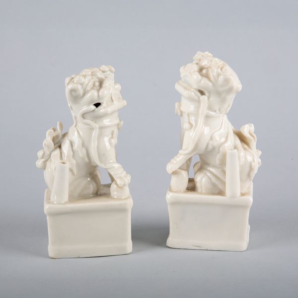 A NEAR PAIR OF CHINESE PORCELAIN BLANC DE CHINE DOGS OF FO