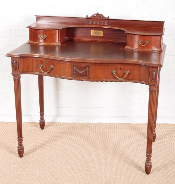 AN EDWARDIAN MAHOGANY LADY'S SERPENTINE FRONTED DESK