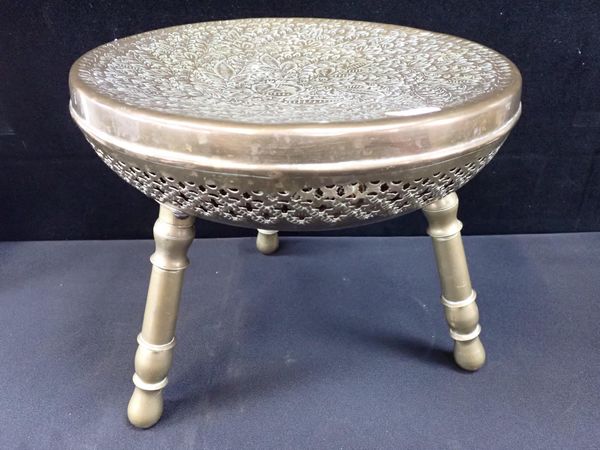 A PIERCED AND ENGRAVED BRASS THREE-LEGGED FOOT WARMER STOOL