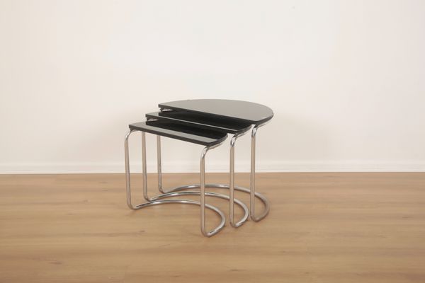 A NEST OF DEMI-LUNE TABLES OF TUBULAR CHROME AND BLACK GLASS