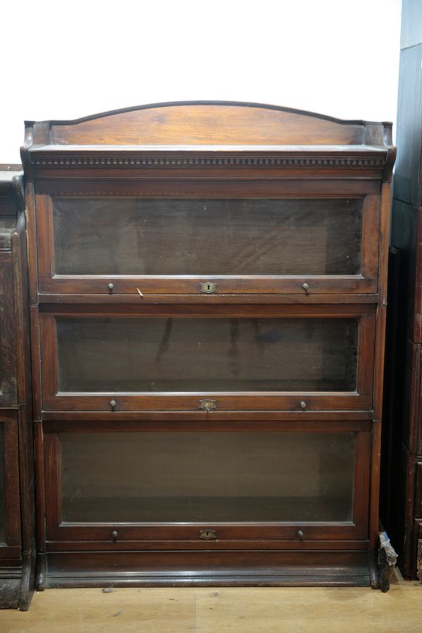 AN EARLY 20TH CENTURY WALNUT THREE TIER SECTIONAL BOOKCASE OF GLOBE WERNICKE DESIGN