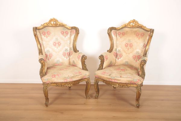 A PAIR OF FRENCH GILTWOOD WING ARMCHAIRS IN LOUIS XV STYLE