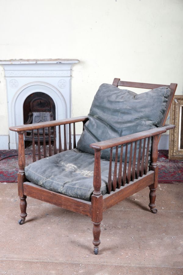 A LATE VICTORIAN OAK RECLINING ARMCHAIR