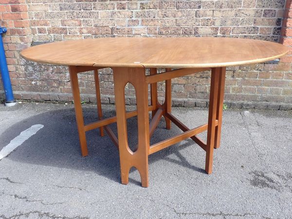 A MID-CENTURY TEAK DROP-LEAF OVAL DINING TABLE