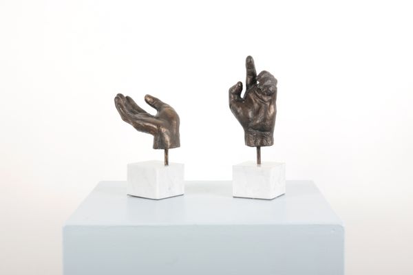 A PAIR OF PATINATED BRONZE GESTURING HAND SCULPTURES