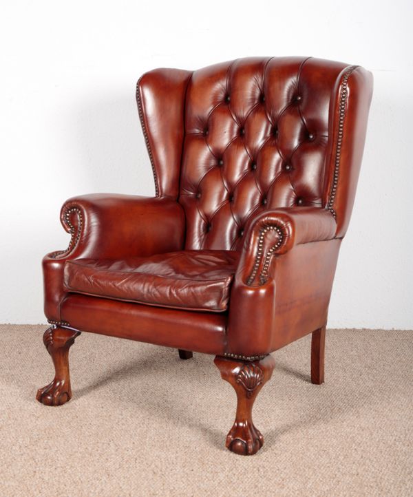 A GEORGIAN STYLE BROWN LEATHER WING BACK CHAIR