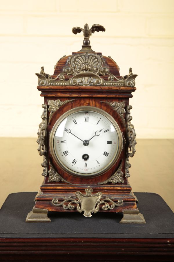 A VICTORIAN OAK AND BRASS MOUNTED MANTEL CLOCK