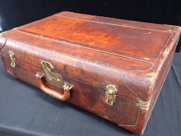 A VINTAGE LEATHER SUITCASE, WITH PATINATED SURFACE