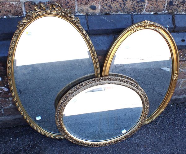 A MOULDED AND GILT FRAMED OVAL MIRROR