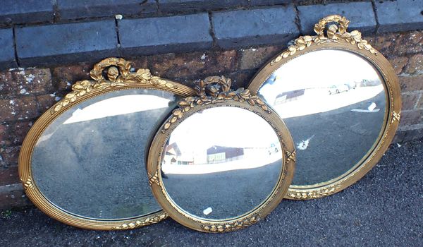 A REGENCY STYLE REEDED AND RIBBON GILT FRAMED CONVEX  MIRROR