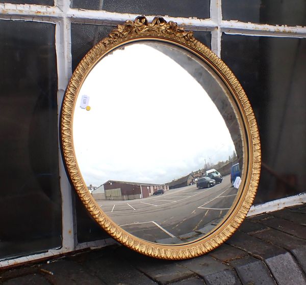 A GILT-FRAMED CONVEX MIRROR