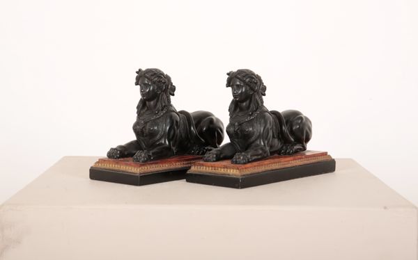 A PAIR OF SPELTER BLACK SPHINX ON FAUX BURR WOOD BASES