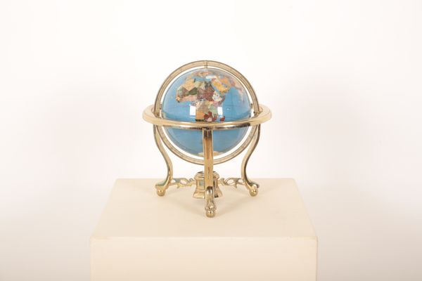 A SEMI-PRECIOUS INLAID GLOBE ON BRASS PLATED REVOLVING STAND