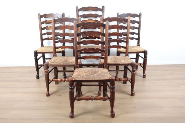 A HARLEQUIN SET OF FIVE OAK LANCASHIRE STYLE LADDERBACK DINING CHAIRS