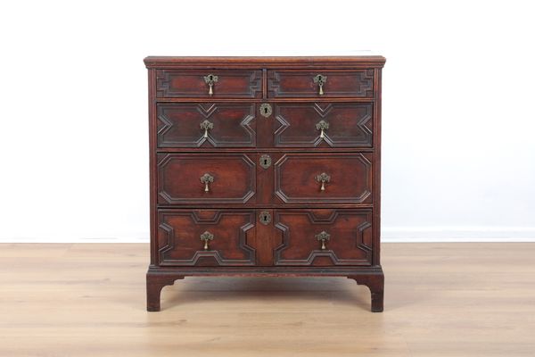 AN OAK CHEST OF DRAWERS
