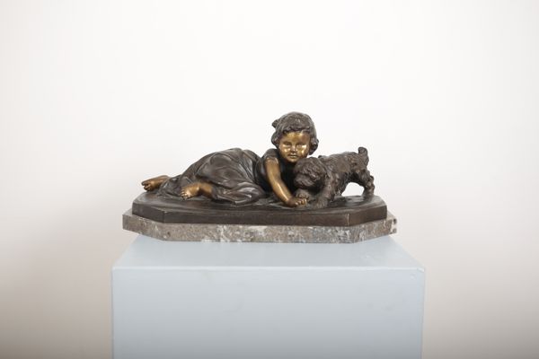 BARBENDIEM (?): A patinated bronze of a girl playing with a puppy