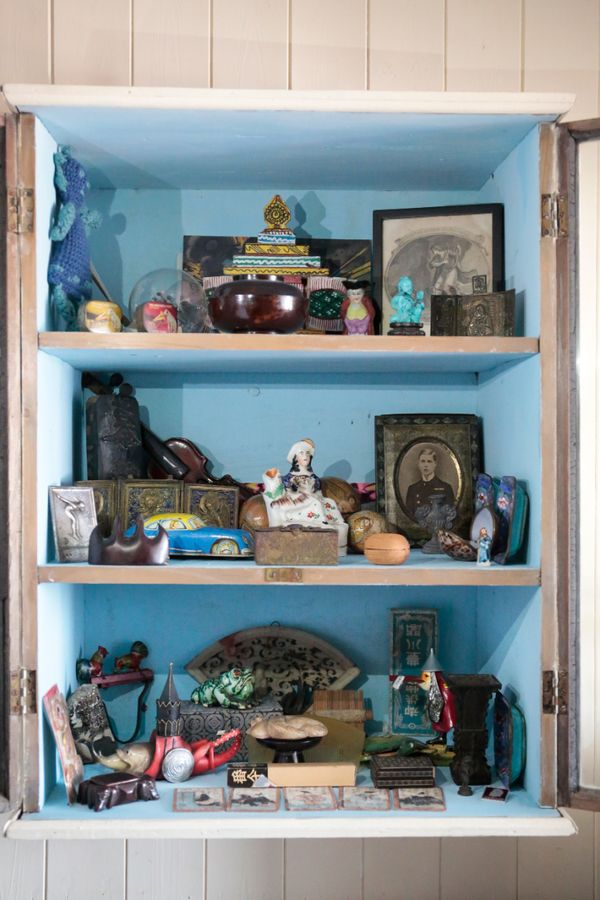 AN EDWARDIAN CREAM-PAINTED CABINET OF CURIOSITIES