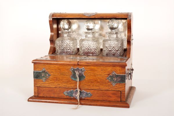 AN EDWARDIAN OAK TANTALUS GAME COMPENDIUM