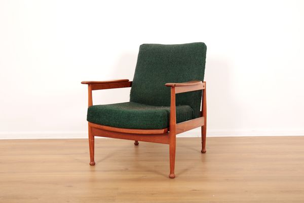 A TEAK RECLINING 'MANHATTAN' ARMCHAIR BY GUY ROGERS, RETAILED BY HEALS