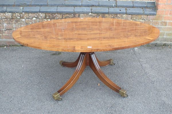 A YEW WOOD VENEERED AND CROSSBANDED OVAL COFFEE TABLE