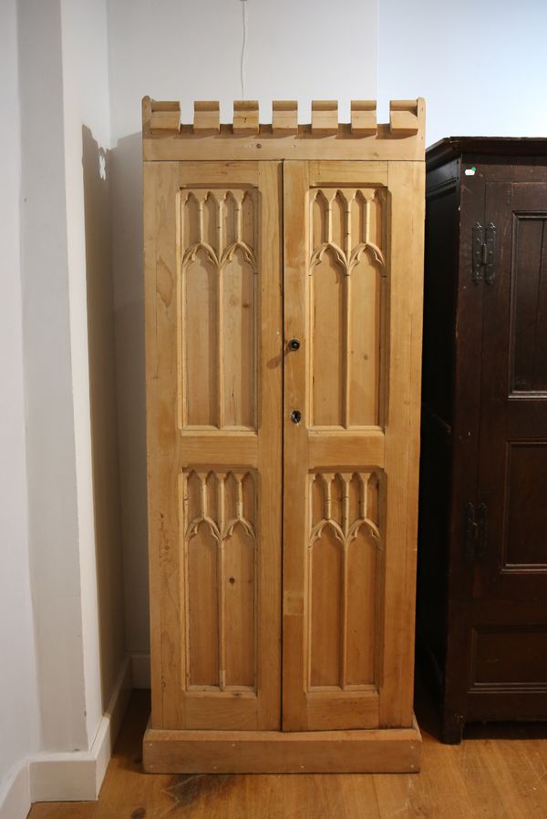 AN EARLY 20TH CENTURY PINE WARDROBE OF GOTHIC DESIGN