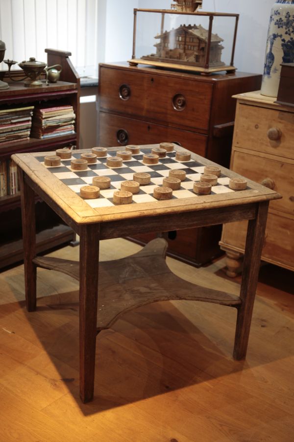 AN EARLY 20TH CENTURY WEATHERED ELM DRAUGHTS TABLE