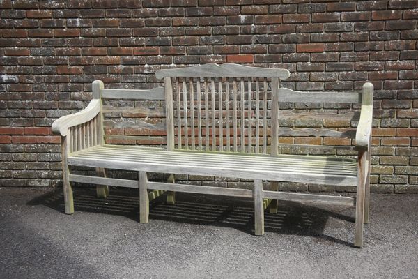 A WEATHERED TEAK GARDEN BENCH