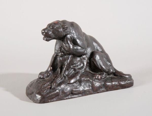 AN UNSIGNED PATINATED IRON SCULPTURE OF A PANTHER CLUTCHING PREY IN ONE PAW