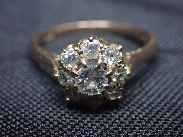 A 9CT GOLD AND DIAMOND FLORAL CLUSTER RING