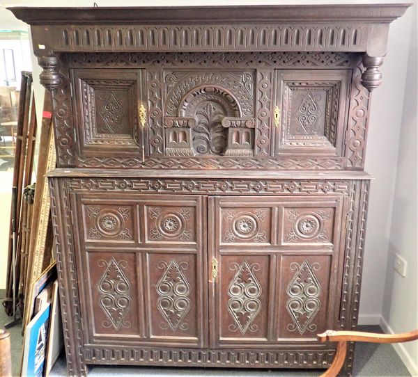 AN OAK COURT CUPBOARD WITH CENTRAL ARCHED PANEL