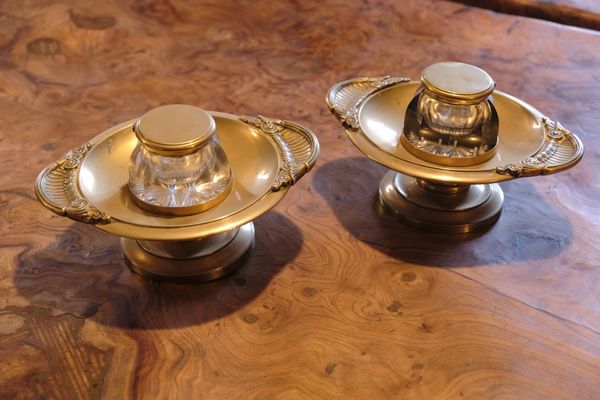 A PAIR OF REGENCY STYLE CUT GLASS AND BRASS MOUNTED INKWELLS