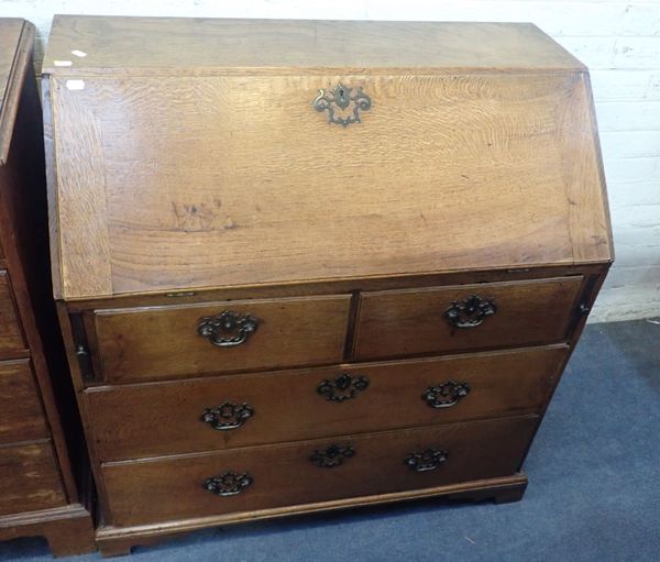 A GEORGE III OAK BUREAU, ON SHORT BRACKET FEET