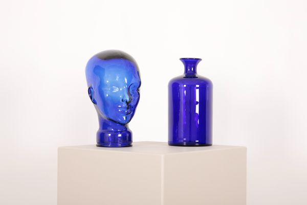 A MOULDED BLUE GLASS MANNEQUIN HEAD