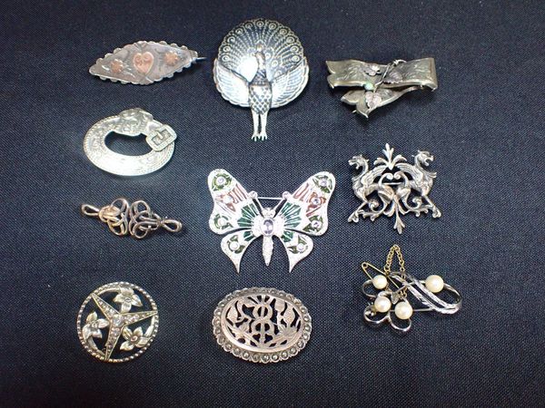 A COLLECTION OF SILVER AND WHITE METAL BROOCHES