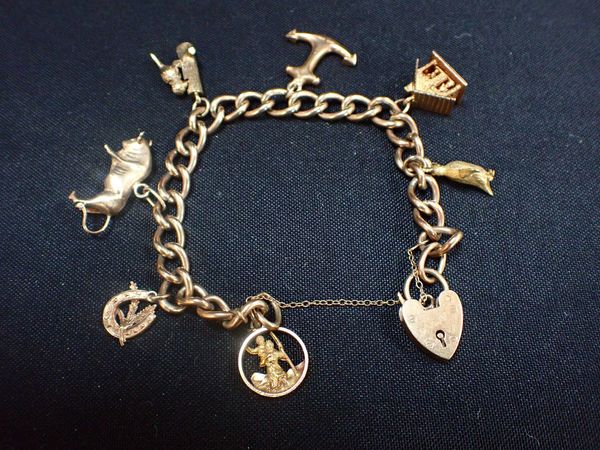 A 9CT AND UNMARKED YELLOW METAL CHARM BRACELET